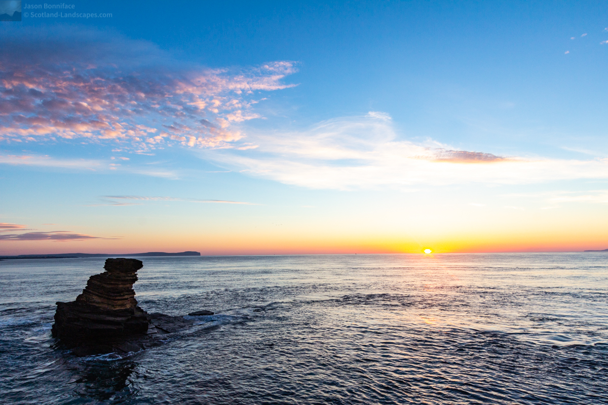 Photo of the Tower o’ Men o’ Mey sea stack with Dunnet Head beyond